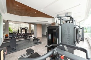 Une salle de sport moderne équipée de matériel d’exercice, d’un banc et d’un support à poids.