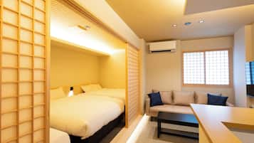 Una habitación de hotel con una cama, un sofá, una mesa y una ventana.