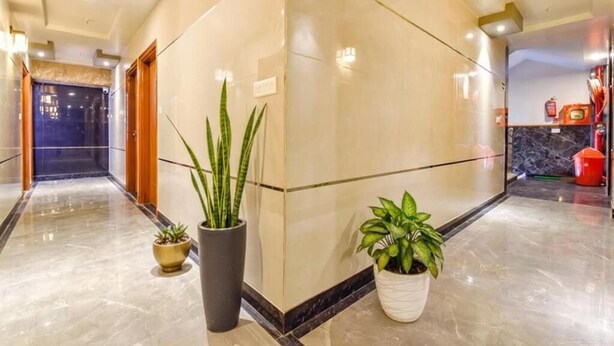 A hotel lobby with a marble floor, a reception desk, and potted plants. - Hotel KPL (Jaipur)
