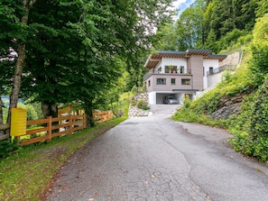 Une maison moderne à deux étages avec une allée menant à un garage.