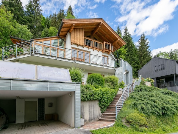 A multi-story building with a wooden balcony, a garage, and a staircase leading to a second level.