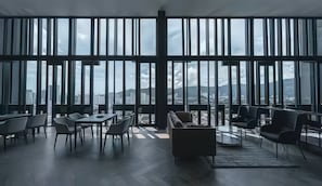 A modern interior with large windows, a dining area, and a seating area with a view of the cityscape. - Beacon EXecutive Suite by Penang (George Town)