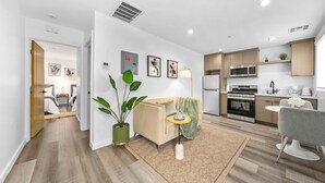 A modern apartment with a living area, kitchen, and dining space. - The Urban Suites (Los Angeles)