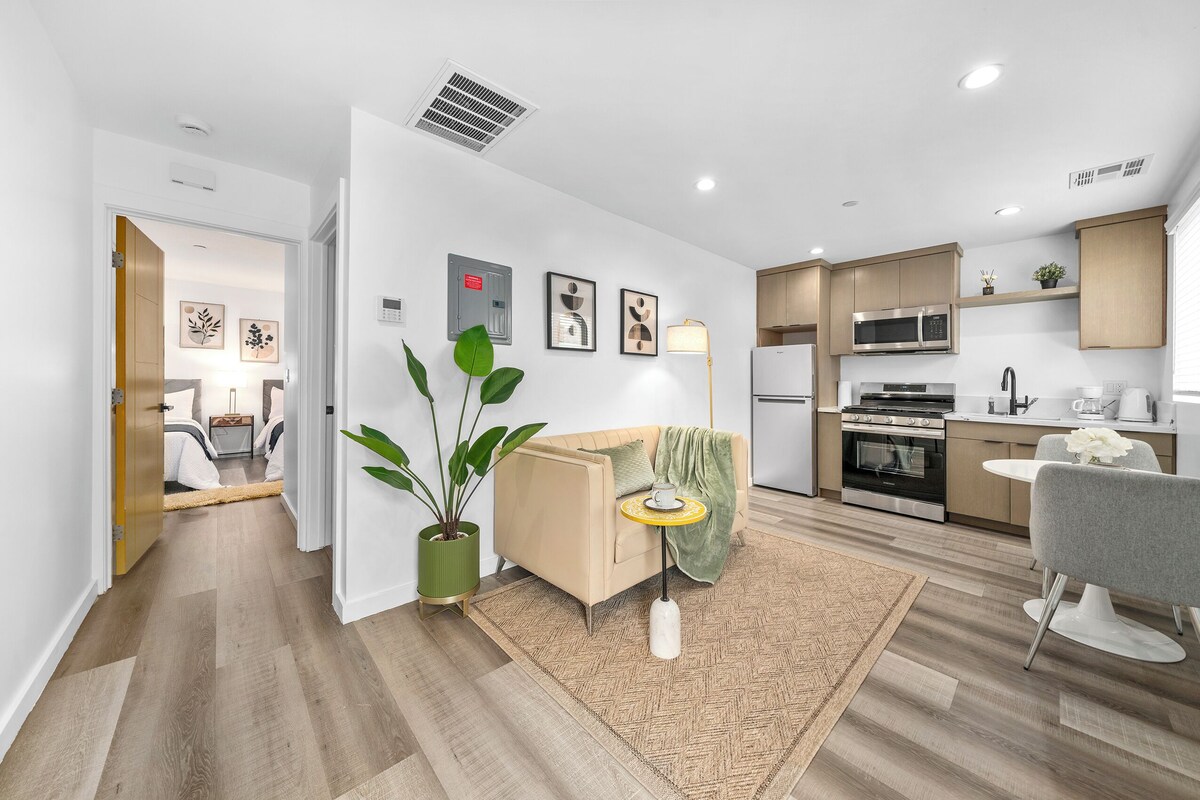 A modern apartment with a living area, kitchen, and dining space.