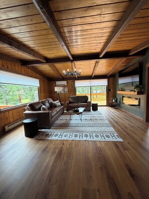 Un intérieur en bois avec un canapé, une table basse et un lustre.