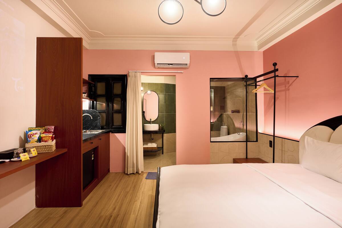 Ein Hotelzimmer mit einem Bett, einem Schminktisch mit Spiegel, einem Waschbecken und einer Duschkabine.