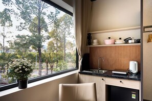 A kitchen with a window, a sink, a countertop, and a potted plant.
