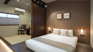 Ein Hotelzimmer mit einem großen Bett, einem Sessel, einer Holzvertäfelung und zwei Wandleuchten.