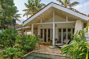 A modern house with a covered patio, a pool, and lush tropical plants. - 3 Bed Villa with Pool 250m to Beach (Ahangama)