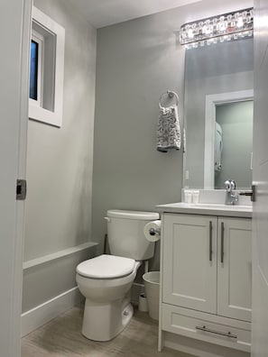 Ein Badezimmer mit Toilette, Waschbecken, Spiegel und Handtuchhalter.