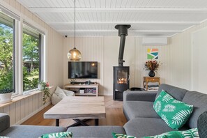 A cozy living room with a fireplace, a television, and a comfortable seating area. - Spacious cottage close to Enebærodde (Otterup)