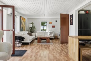 Un salon moderne avec un canapé blanc, une table basse en bois et un meuble en bois.
