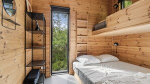 A wooden cabin bedroom with a bed, shelves, and a window. - Modern holiday home near Dueodde Beach (Nexø)