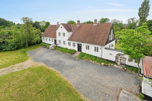 A white house with a gravel driveway and a garden. - Large charming house for 12 guests (Snøde)