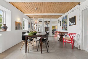 Ein Essbereich mit Holzboden, einem runden Tisch mit Stühlen und Bildern an den Wänden.