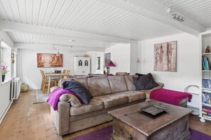 Ein Wohnzimmer mit einer Couch, einem Holztisch und einem Bücherregal.