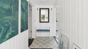 A hallway with a bench, white walls, and a tiled floor. - Idyllic Old Cottage, with low ceilings (Bredebro)