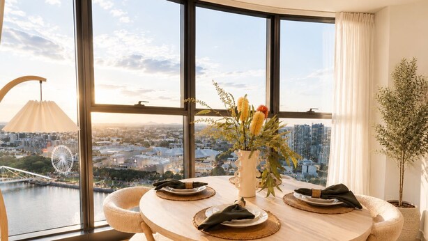 Een moderne eetruimte met een panoramisch stadszicht, een ronde tafel en comfortabele zitplaatsen.