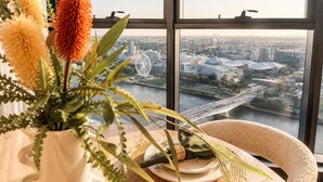 Een kamer met een groot raam met uitzicht op een stadsbeeld, inclusief een brug en gebouwen.