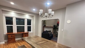 A dining area with a long wooden table, benches, and a chandelier. - Terrific 5-bedroom charming house in older neighborhood in Salem (Salem)