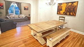A dining area with a wooden table, benches, a chandelier, and a painting on the wall. - Terrific 5-bedroom charming house in older neighborhood in Salem (Salem)