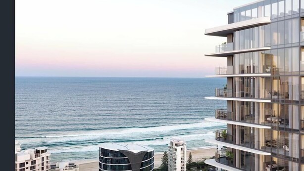 Un moderno edificio a più piani con balconi che si affacciano su una spiaggia e l'oceano.