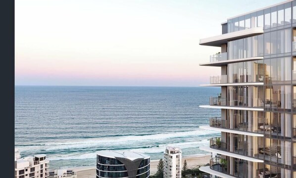 A modern multi-story building with balconies overlooking a beach and ocean. - Amaya (Broadbeach)