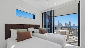A modern hotel room with two beds, a large window, and a city view. - Amaya (Broadbeach)