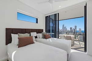 Una habitación de hotel moderna con dos camas, un ventanal grande y vistas a la ciudad.