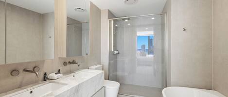 Un baño moderno con un espejo grande, cabina de ducha, bañera y retrete.