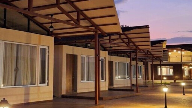 Un espacio al aire libre techado, con suelo de baldosas y una serie de edificios con amplias ventanas.