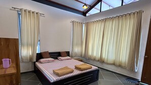 Un dormitorio con cama, cortinas, ventilador de techo y ventana.