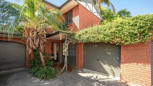 A residential property with a brick facade, a garage, and a covered entrance. - Belle Escapes - Glenelg Urban Escape (Holdfast Bay)