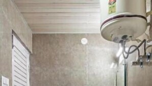 Un bagno con il water, un lavandino e una doccia con soffione manuale.