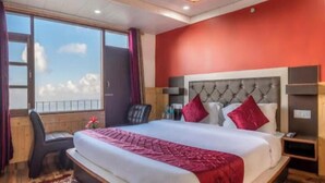 Una camera d'albergo con un letto grande, una scrivania e vista sul cielo.