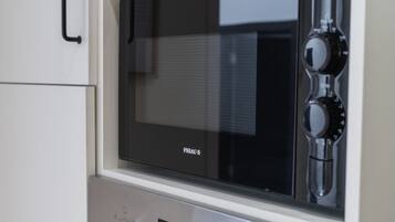 A black microwave oven with a digital display, a control knob, and a brand name visible on the front.