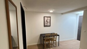 Ein Essbereich mit Tisch und Stühlen, einem gerahmten Kunstwerk an der Wand und einem Holzboden.