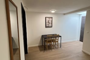 Ein Essbereich mit Tisch und Stühlen, einem gerahmten Kunstwerk an der Wand und einem Holzboden.