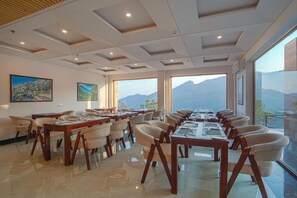 Un salón de conferencias con una larga mesa y sillas, ventanas amplias con vista a la montaña y obras de arte en las paredes.