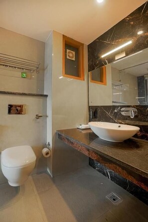Un baño moderno con inodoro, lavabo y espejo.