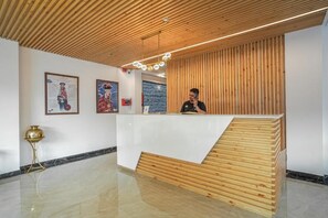 Un área de recepción con mostrador de madera, obras de arte enmarcadas en las paredes y un suelo pulido.