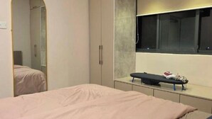 A bedroom with a bed, a wardrobe, a mirror, and a window. - Cozy 1-bedroom studio in Hulhumale' with AC comfort (Malé)