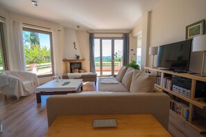 Un salon avec un canapé, une table basse, un téléviseur et une bibliothèque.