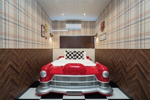 A room with a bed designed like a red car, plaid wallpaper, and a wooden herringbone floor. - JAPAVISTA Unlimited (Baika, Konohana Ward)