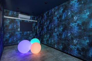 A room with a space-themed wall mural, a mounted air conditioner, and three illuminated spheres on the floor. - JAPAVISTA Unlimited (Baika, Konohana Ward)