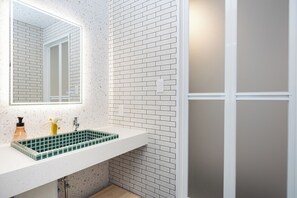 A bathroom with a white sink, a mirror, and a tiled backsplash. - JAPAVISTA Unlimited (Baika, Konohana Ward)
