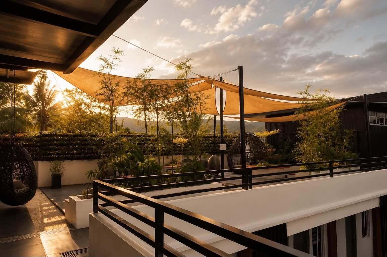 An outdoor terrace with a canopy, seating area, and a view of the surrounding landscape.