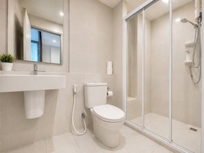 A modern bathroom with a toilet, sink, and glass shower enclosure. - Sea View 2 Bed Room I Best Of Location (Pattaya)