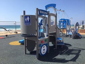 A playground with a 'Welcome' sign, a slide, and exercise equipment. - Vacation apartment first line view to the sea, fully equipped penthouse (Bat Yam)