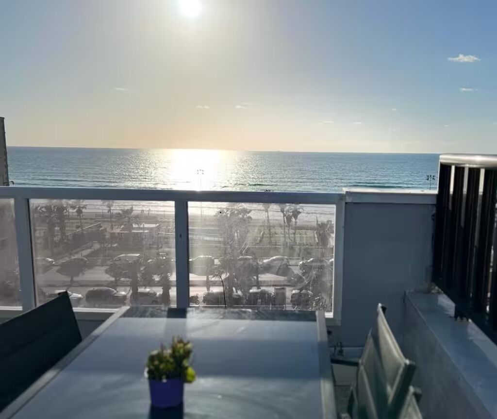 Ein Balkon mit Meerblick und ein Parkplatz.